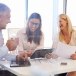 Group of colleagues meeting around a table in an office