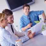 business woman showing papers to colleagues