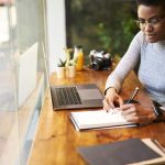 person making notes while working in office
