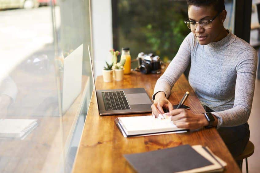 person making notes while working in office
