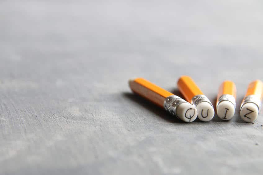 The word "quiz" with each letter on the eraser of four yellow pencils