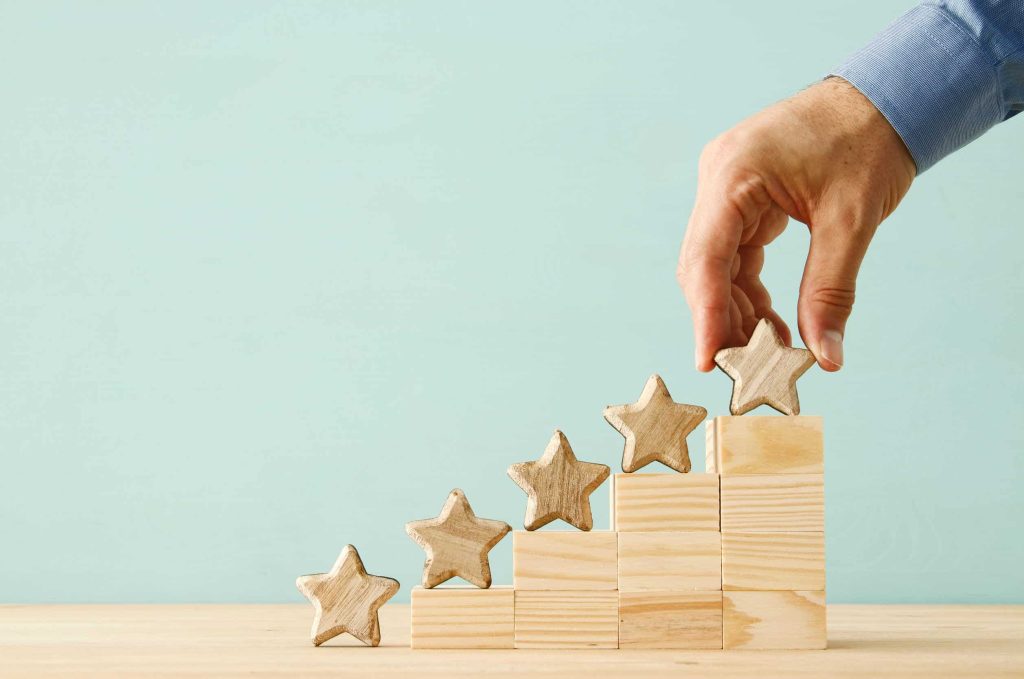 a person setting five stars on a staircase, aiming to reach their goals