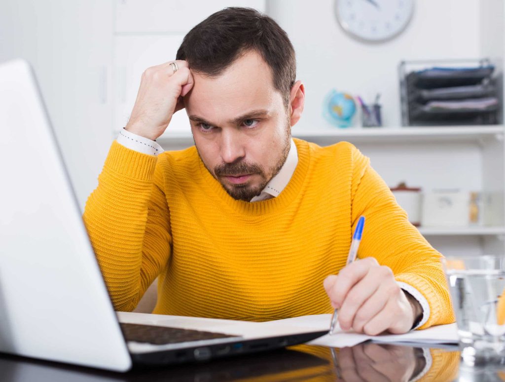 a young man facing a challenge, problem-solving at the computer