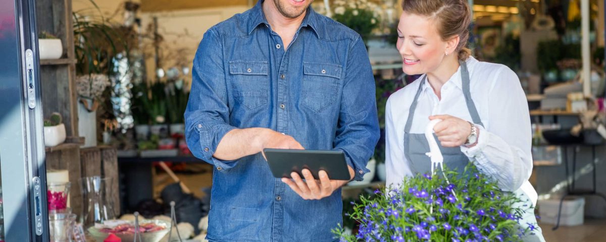 a male customer using a tablet to order from a female florist