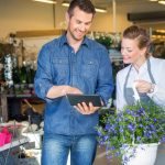 a male customer using a tablet to order from a female florist