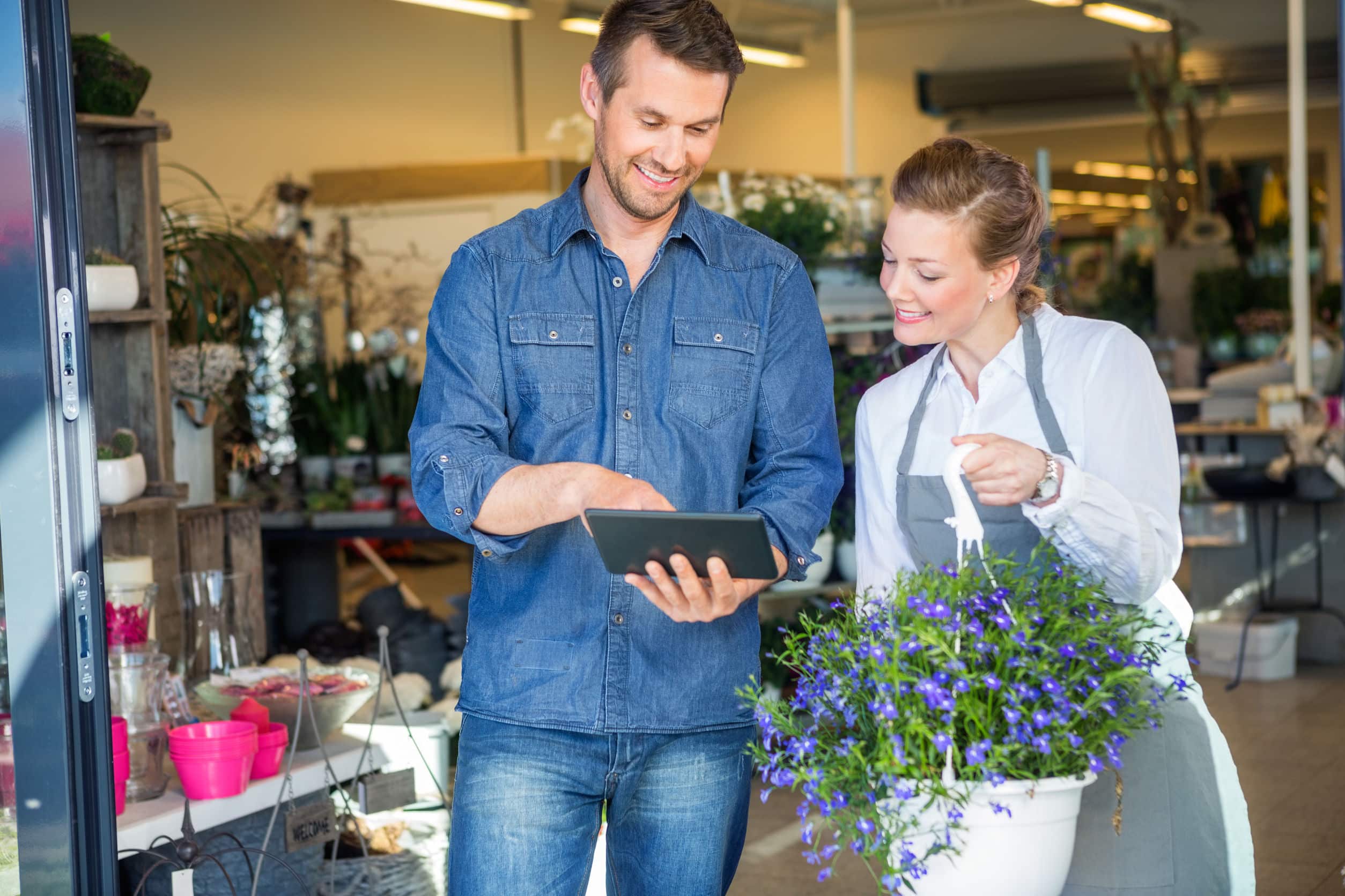 a male customer using a tablet to order from a female florist
