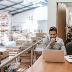 Business owner working on marketing in a warehouse.