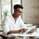 a smiling businessman using his tablet in a coffee shop