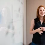 a smiling businesswoman promoting her company during a presentation