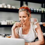 woman sitting alone and using her laptop in her workshop