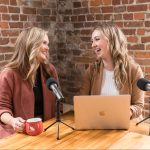 Kelly and Victoria laughing during a podcast.