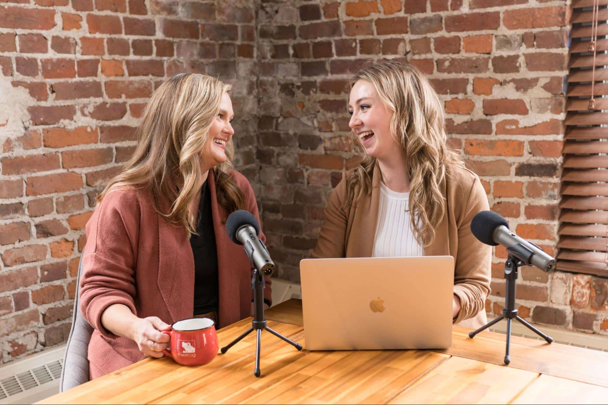 Kelly and Victoria laughing during a podcast.