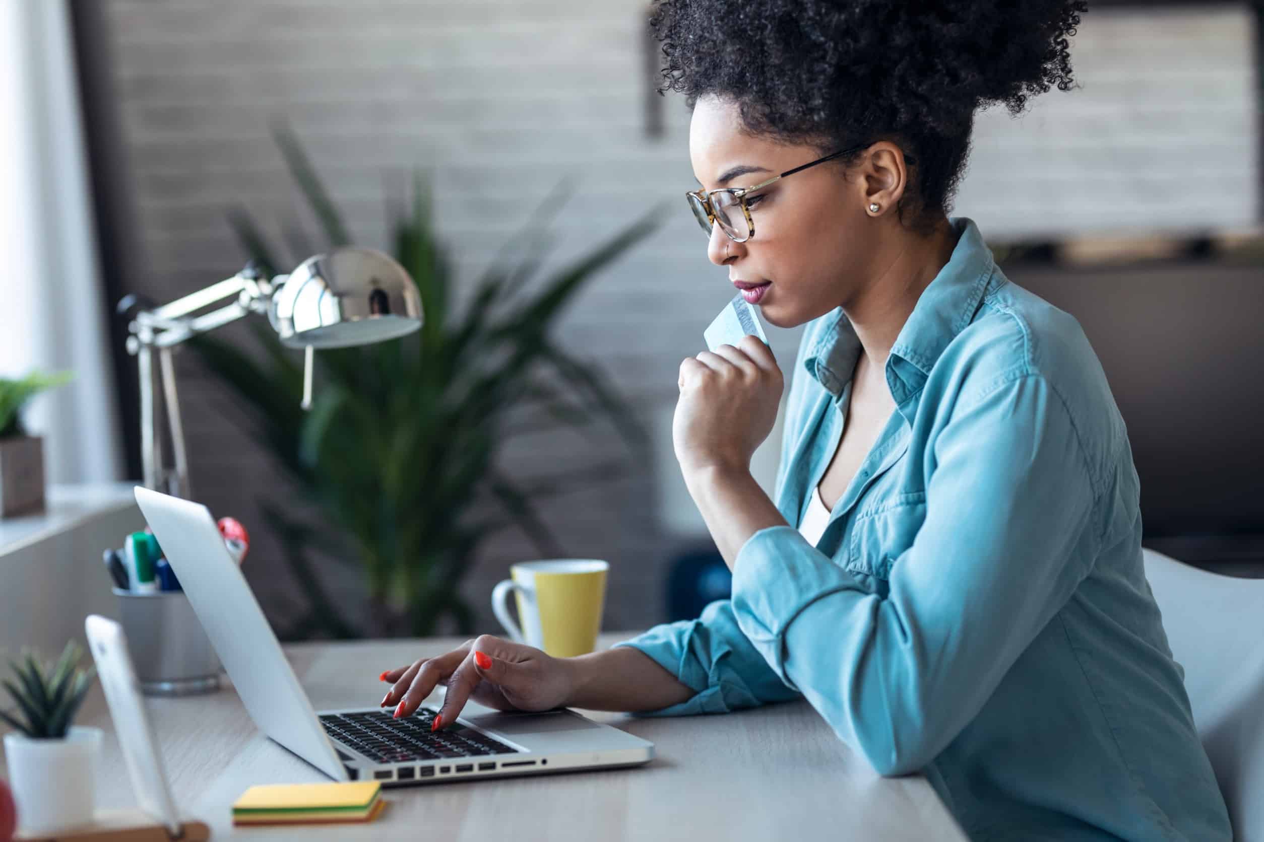 woman sitting alone and using her laptop to make an online purchase