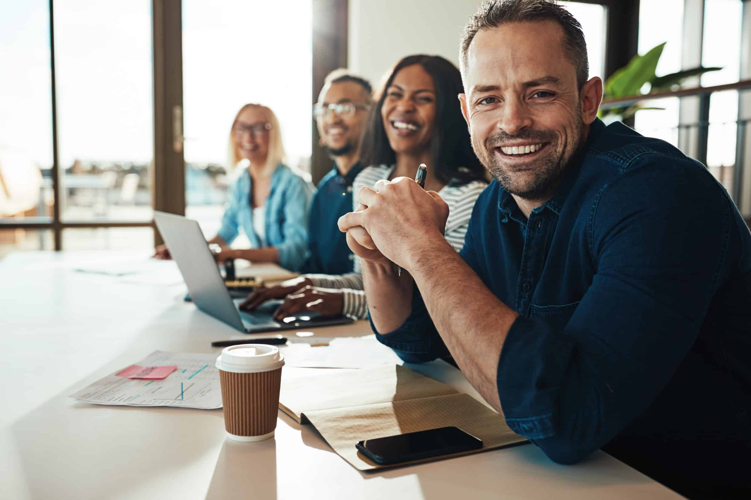 a marketing team sitting at a conference table reviewing their internet marketing strategy