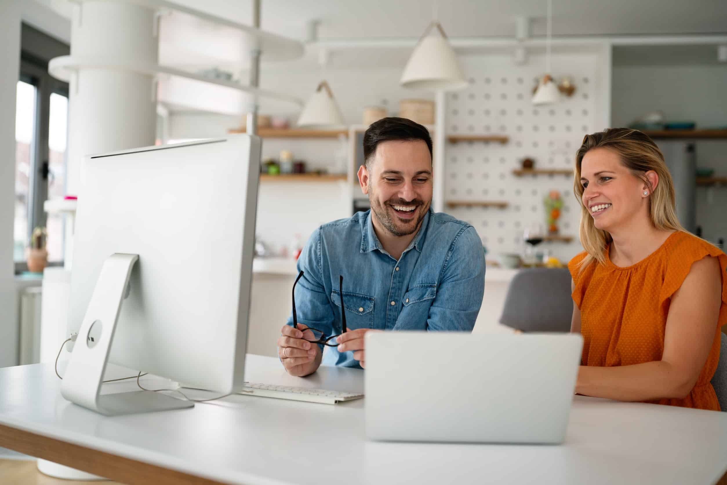 coworkers talking and looking at a computer screen discussing a lead generation website
